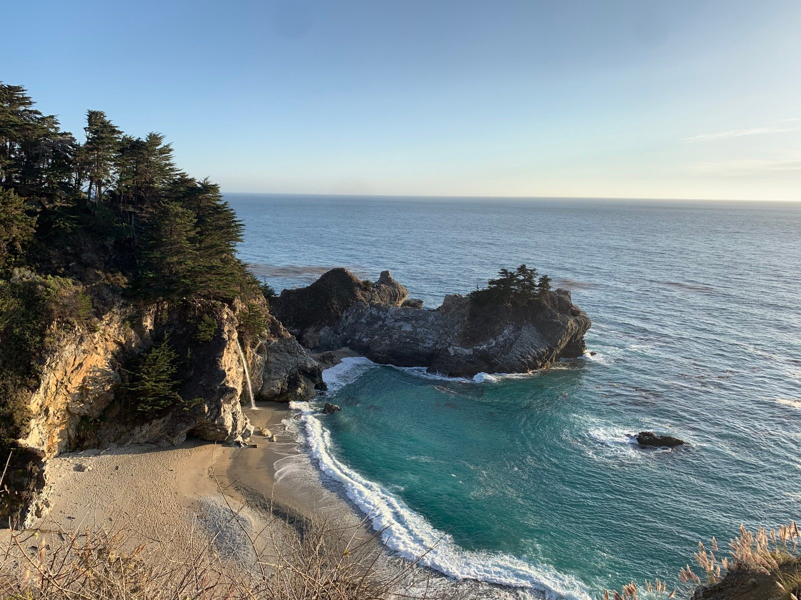 Scenic view of McWay Falls running into the ocean with coastal cliffs