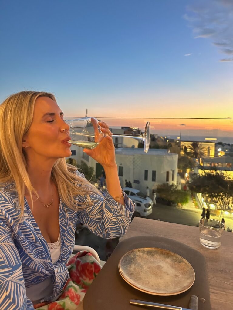 Rooftop glass of wine at Sunset in Santorini Greece on Honeymoon